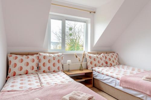 a bedroom with two beds and a window at Pokoje i Apartamenty Marek - Niedaleko Plaży in Ostrowo