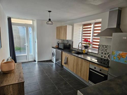 une cuisine avec un évier et une cuisinière dans l'établissement Le centre-ville du Berry, à Châteauroux