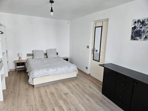 une chambre blanche avec un lit et une commode dans l'établissement Le centre-ville du Berry, à Châteauroux