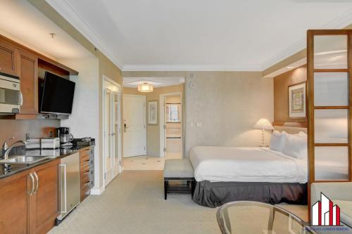 a hotel room with a bed and a kitchen at MGM Signature-25-609 Strip View Jacuzzi Studio in Las Vegas