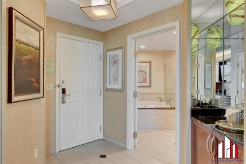 La salle de bains est pourvue d'une porte blanche et d'un lavabo. dans l'établissement MGM Signature-25-609 Strip View Jacuzzi Studio, à Las Vegas