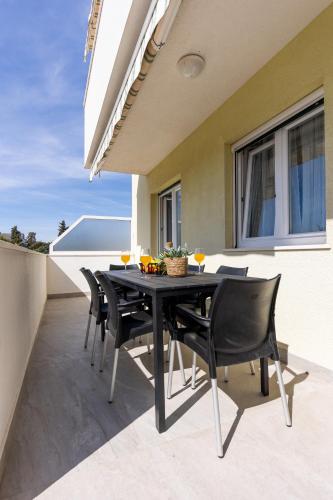 a black table and chairs on a patio at Villa Koludrovac in Kaštela