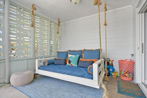 a swinging bed in a room with blue pillows at Heated Pool by the Sea Mini Golf Dogs OK in Saint Augustine