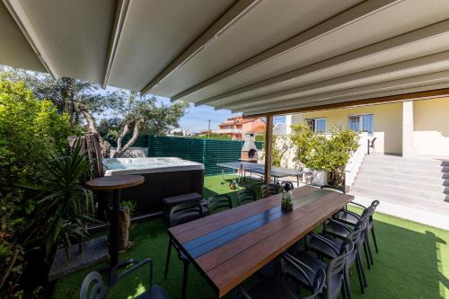 an outdoor patio with a wooden table and chairs at Villa Koludrovac in Kaštela