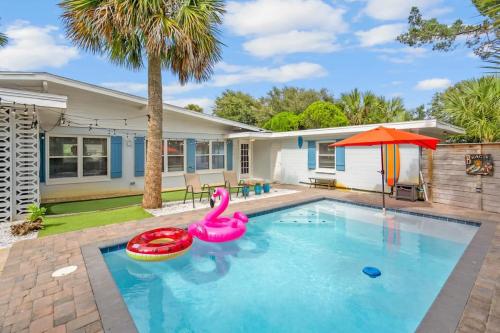 a swimming pool with a pink flamingos in front of a house at Heated Pool by the Sea Mini Golf Dogs OK in Saint Augustine