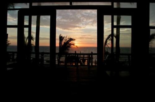 a view of the ocean from a window with the sunset at HOTEL RUSTICA VICHAYITO in Vichayito