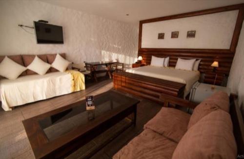 a living room with two beds and a couch at HOTEL RUSTICA VICHAYITO in Vichayito