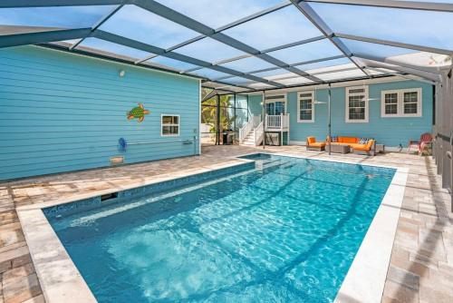 a swimming pool in front of a blue house at Sparkling Blue Pool Home! Walk to Beach, Publix in St. Augustine