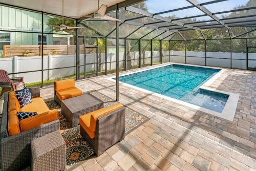 a swimming pool in a glass house with a patio at Sparkling Blue Pool Home! Walk to Beach, Publix in St. Augustine