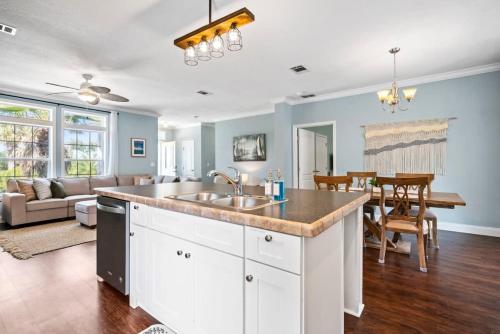 a kitchen with a sink and a living room at Sparkling Blue Pool Home! Walk to Beach, Publix in St. Augustine