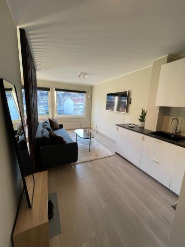 sala de estar con sofá y cocina en Modern apartment ONLY 5 minutes from City Centre, en Bergen