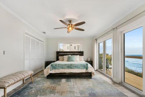 Schlafzimmer mit einem Bett und einem Deckenventilator in der Unterkunft Spectacular Oceanfront! Blissful Balconies + BBQ in St. Augustine
