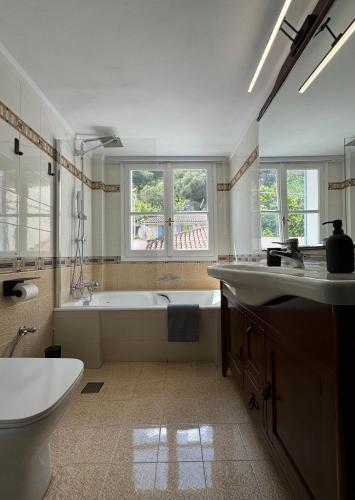 a bathroom with a tub and a toilet and a sink at S&F Luxury Apartment in Nafplio