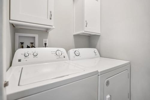 a white laundry room with a washer and dryer at Canal Front Home! Walk to Beach, Porch, Fishing in St. Augustine
