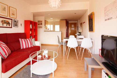 uma sala de estar com um sofá vermelho e uma mesa em LUMINOSO. COMODO. ACOGEDOR. WIFI. Junto a AVE em Valência