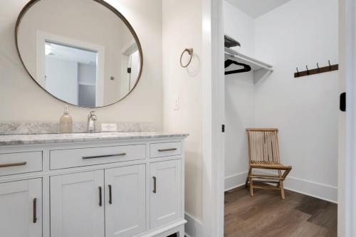 a white bathroom with a mirror and a chair at Blue House, Prime Location, Family Amenities, BBQ! in Saint Augustine