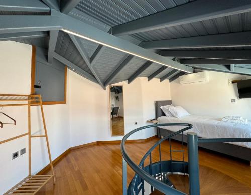 a loft bedroom with a bed and a staircase at S&F Luxury Apartment in Nafplio