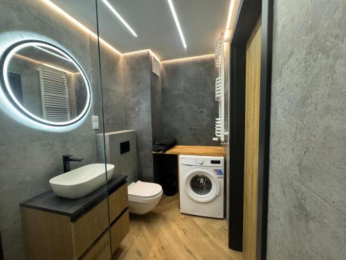 ein Badezimmer mit einer Waschmaschine und einer Waschmaschine in der Unterkunft Blue Sky 39 in Danzig