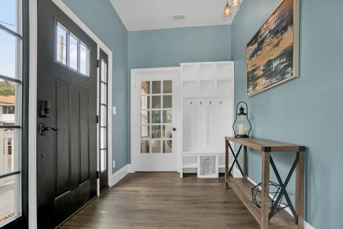 a hallway with a black door and a wooden table at Charming Cottage w Pool, Walkable to Downtown in St. Augustine