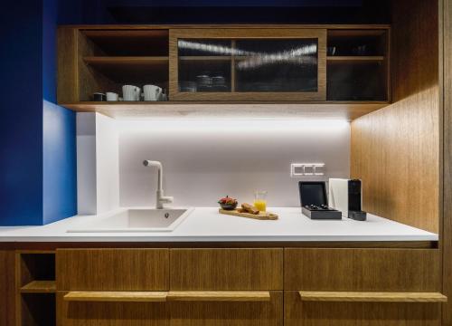 a kitchen with a sink and wooden cabinets at Epineio Comfort Living in Litochoro