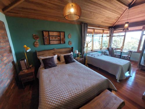 - une chambre avec 2 lits dans une pièce aux murs verts dans l'établissement Hospedaria Aikó, à São Bento do Sapucaí