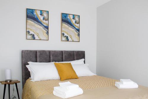 una camera da letto con un letto con tre dipinti sul muro di Dreamscape Villa a Ponta Delgada