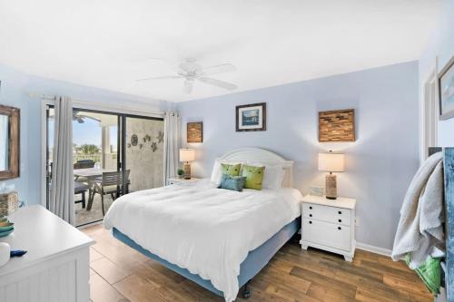 een slaapkamer met een groot wit bed en een tafel bij Stunning Ocean Views, Huge Patio, Heated Pool and Amenities! in St. Augustine