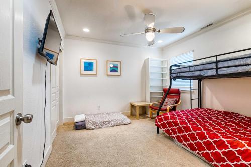 a bedroom with a red bed and a ceiling fan at Peaceful Petaluma Getaway with Deck and Grill! in Petaluma
