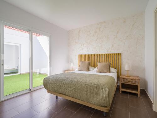 a bedroom with a bed and a large window at Pasito Blanco Villas in Pasito Blanco