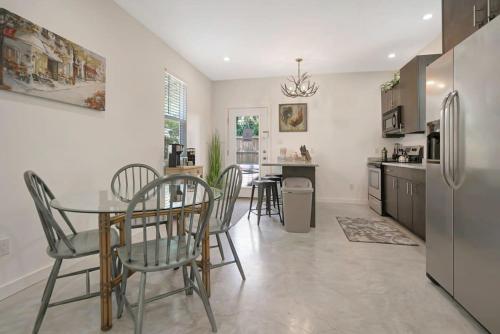 a kitchen with a table and chairs and a refrigerator at Downtown Home with Hot Tub, BBQ, Near Ice Plant! in Saint Augustine