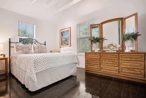 a bedroom with a bed and a dresser and a mirror at Downtown Home with Hot Tub, BBQ, Near Ice Plant! in Saint Augustine