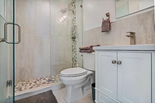 a bathroom with a white toilet and a shower at Ocean Views Retreat! Renovated Apt with Beach Bikes! in Saint Augustine