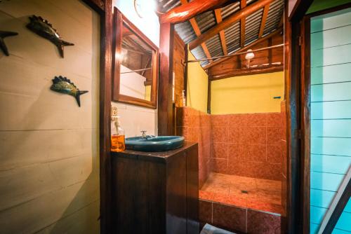 a bathroom with a sink and a shower at Hotel Casa Perico in Rio Dulce