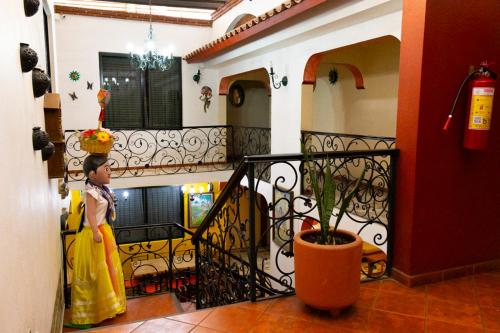 une femme avec un gâteau sur la tête debout sur un balcon dans l'établissement Hotel Doña Alicia, à Oaxaca