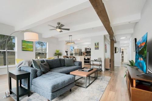 a living room with a blue couch and a tv at Park It At the Butterfield Garage, Historic Pre-Prohibition Style Apt in the Heart of Downtown in St. Augustine