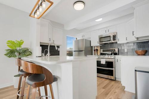 a kitchen with white cabinets and a white counter top at Park It At the Butterfield Garage, Historic Pre-Prohibition Style Apt in the Heart of Downtown in St. Augustine