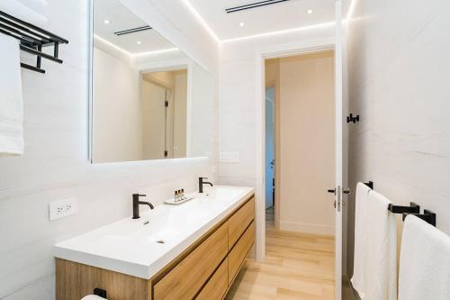 bagno con lavandino e specchio di Seven Mile Beach Luxury 3BR Condo- Best Rates! a George Town