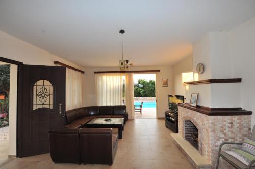 a living room with a couch and a fireplace at Jaime Villa Cyprus in Argaka