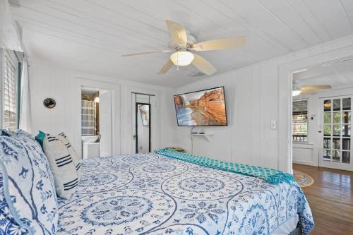 a bedroom with a bed with a ceiling fan at Marvelous Mermaid Bungalow, Dog-Friendly Upstairs Apt in Prime Vilano Beach in St. Augustine
