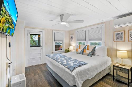 a bedroom with a large bed and a flat screen tv at Marvelous Mermaid Bungalow, Dog-Friendly Downstairs Apt in Prime Vilano Beach in Saint Augustine