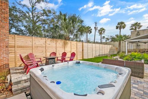 a hot tub in a backyard with chairs and a table at Remodeled Historic 1800s Carriage House, The Castle Garden, Colonial Modern Mansion in St. Augustine