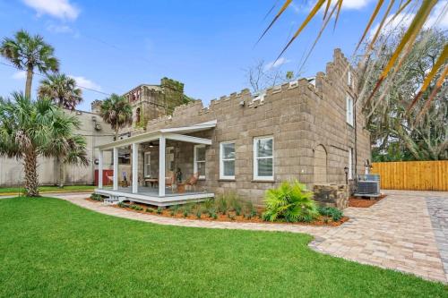 a brick house with a patio and a yard at Remodeled Historic 1800s Carriage House, The Castle Garden, Colonial Modern Mansion in St. Augustine