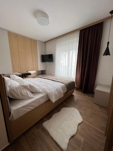 a bedroom with a large bed and a television at Verde Apartman Sokobanja in Soko Banja