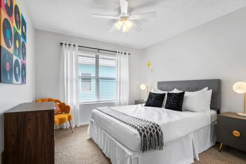 a white bedroom with a bed and a window at The Atomic Burst 50s Mid Century Apt in the Heart of St Aug Beach Steps to Sand Bites and Drinks in Saint Augustine