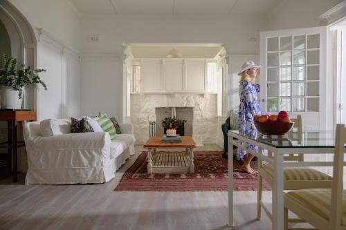 Una mujer parada en una sala de estar con chimenea. en Kalimera Beach House, en Mossel Bay