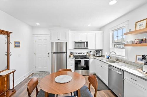 a kitchen with white cabinets and a wooden table at City Living West Downtown St Aug Apartment in St. Augustine