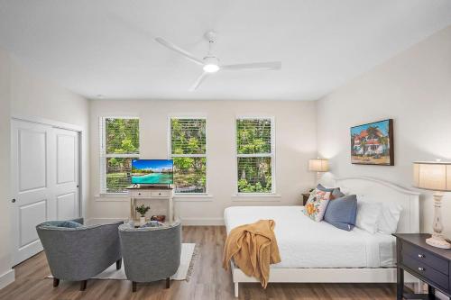 a white bedroom with a bed and windows at New Private Apt in Uptown St Aug Walk Everywhere in St. Augustine