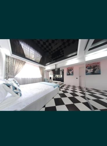 um quarto com piso em xadrez e 2 camas em ONYX Apartament em Braila