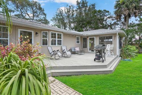 a house with a deck with chairs and a grill at Onyx House King Size Beds Bikes Games Wine in St. Augustine