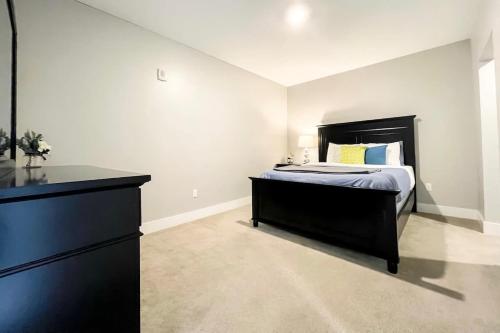 a bedroom with a black bed and a dresser at 2BR 2BA Top Floor DT GR Penthouse Parking &Gym in Grand Rapids